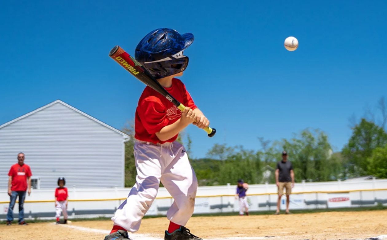 Little kid swinging bat at baseball